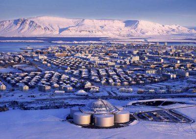 Perlan i forgrund af den vinterklædte Reykjavik. Rejser til Island med ISLANDSREJSER